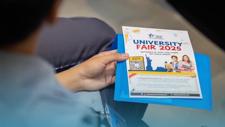 Visitor holding a University Fair 2025 flyer